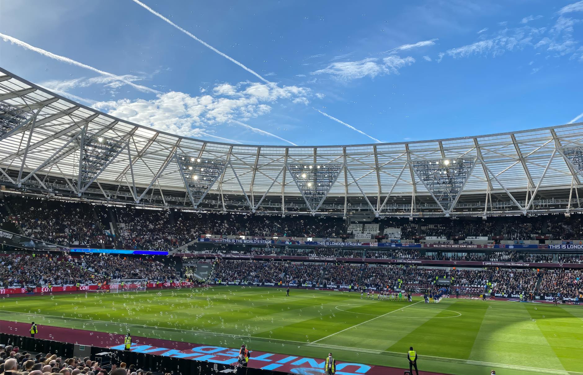 A packed London Stadium hosts a thrilling soccer match, with vibrant atmosphere and engaged crowd.
