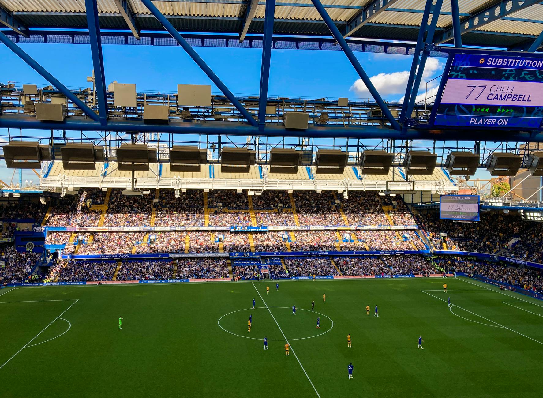 A lively football match in Stamford, England capturing the crowd and players in a filled stadium.